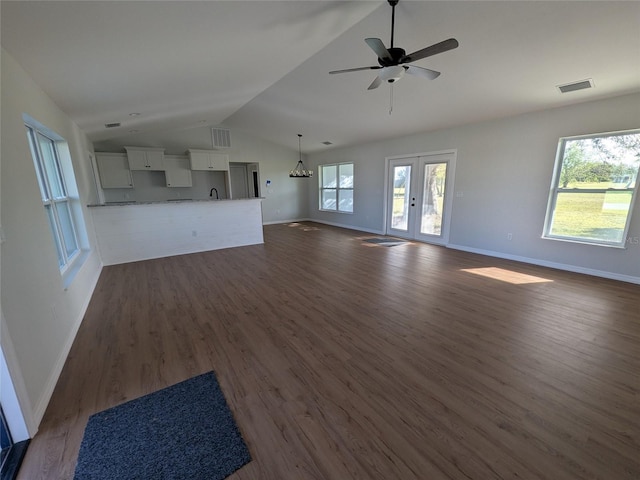 unfurnished living room with lofted ceiling, dark wood-style floors, baseboards, and visible vents