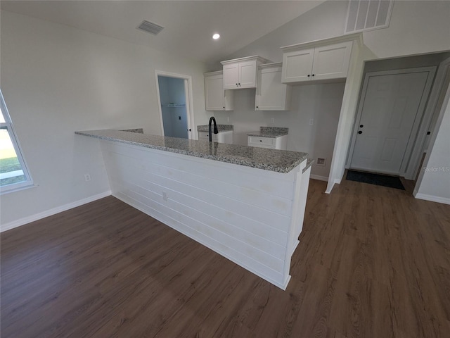 kitchen with a peninsula, white cabinetry, visible vents, and lofted ceiling