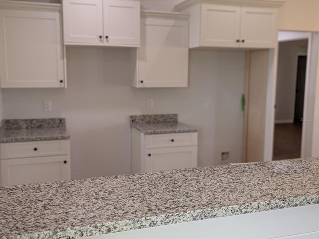 kitchen featuring white cabinetry and light stone counters