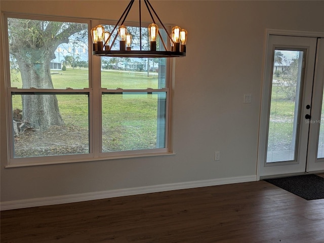 unfurnished dining area with a healthy amount of sunlight, baseboards, and wood finished floors