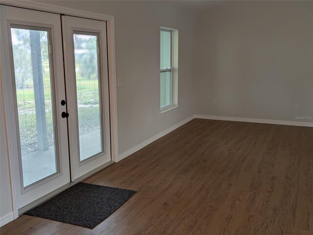 doorway with french doors, baseboards, and wood finished floors