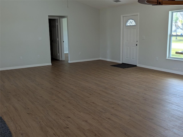 foyer with dark wood-type flooring, plenty of natural light, visible vents, and baseboards