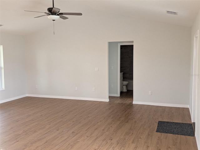 spare room featuring lofted ceiling, ceiling fan, wood finished floors, visible vents, and baseboards