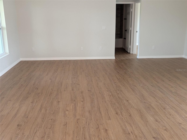 spare room with wood finished floors and baseboards