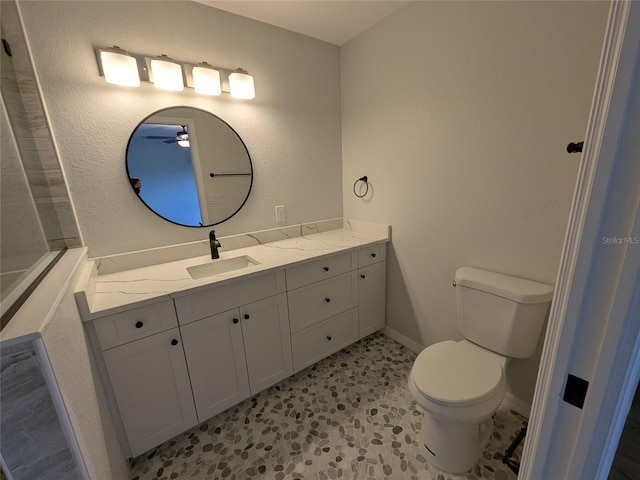 bathroom featuring toilet, baseboards, and vanity