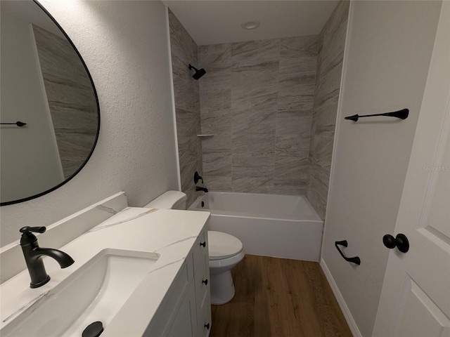 full bathroom featuring a textured wall, toilet, wood finished floors, vanity, and  shower combination