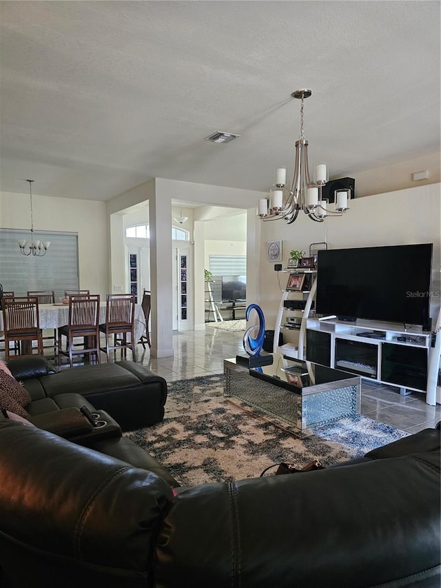 living room featuring visible vents and an inviting chandelier