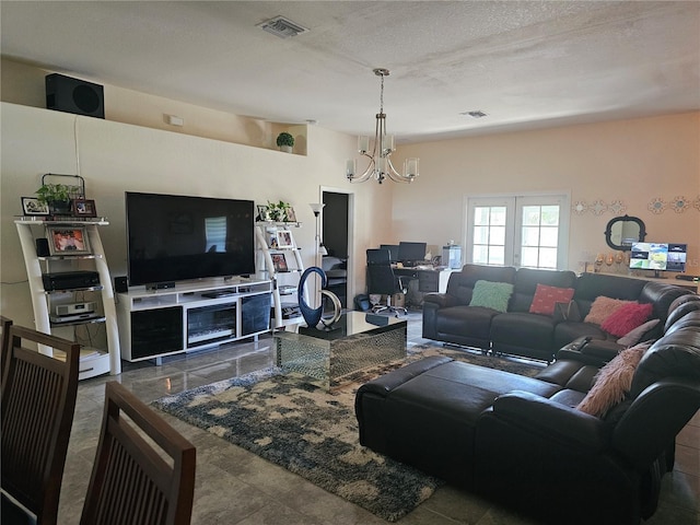 living room with a textured ceiling, visible vents, and a chandelier