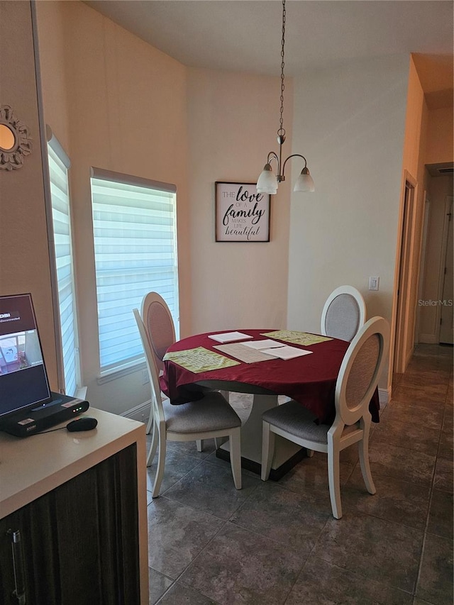 dining area with an inviting chandelier and baseboards
