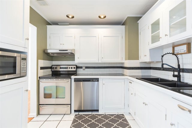 kitchen with appliances with stainless steel finishes, a sink, white cabinets, and under cabinet range hood