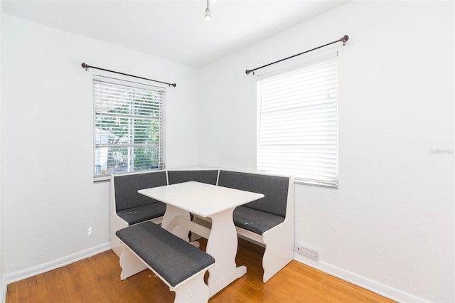 dining area with baseboards, breakfast area, and wood finished floors