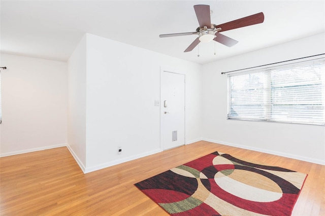 empty room with light wood-style floors, baseboards, and a ceiling fan