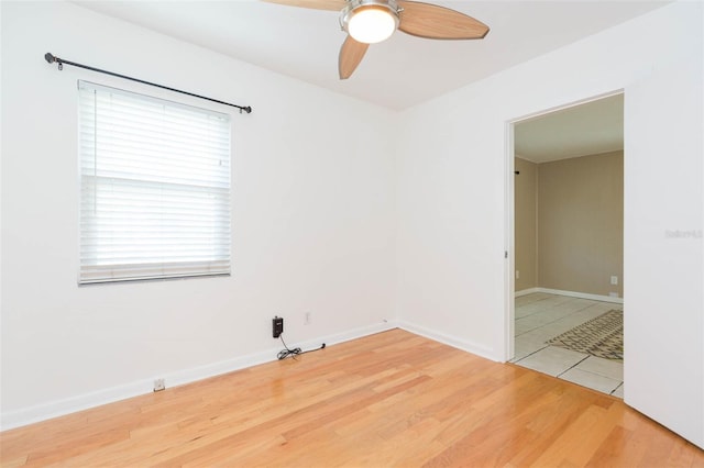 unfurnished room with a ceiling fan, light wood-style flooring, and baseboards