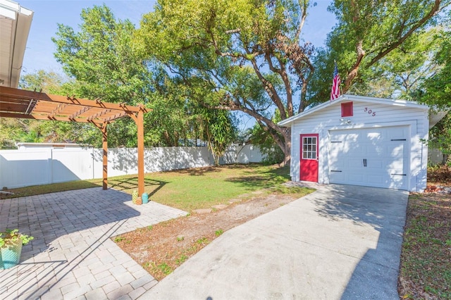 view of yard featuring an outbuilding, concrete driveway, fence, and a pergola