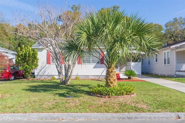 view of side of property with driveway and a lawn