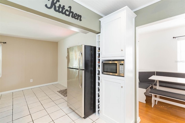 kitchen featuring white cabinetry, stainless steel appliances, and ornamental molding