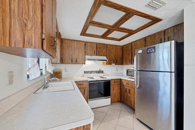 kitchen featuring a sink, stainless steel appliances, light countertops, under cabinet range hood, and brown cabinets