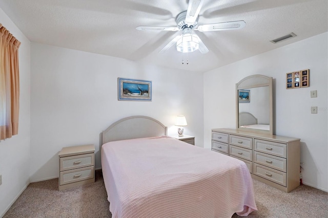 bedroom featuring light colored carpet, visible vents, and ceiling fan