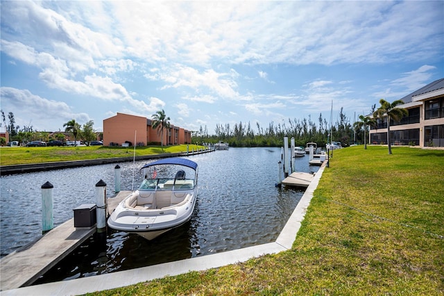 view of dock with a yard and a water view