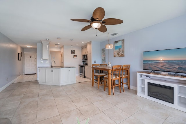 kitchen with light tile patterned floors, appliances with stainless steel finishes, a sink, and visible vents