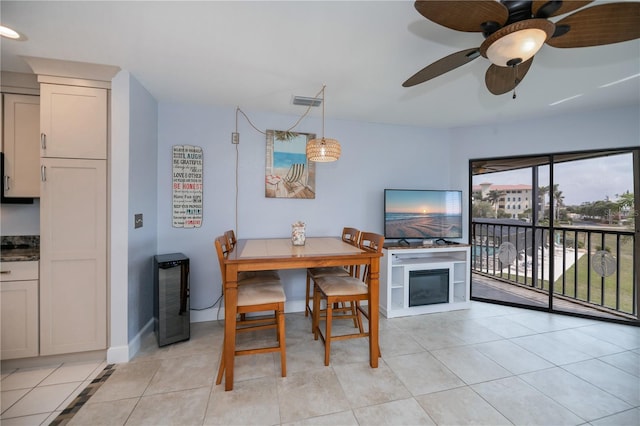 dining area featuring wine cooler, light tile patterned flooring, visible vents, and baseboards