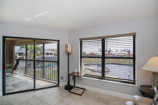 doorway to outside featuring tile patterned floors and baseboards