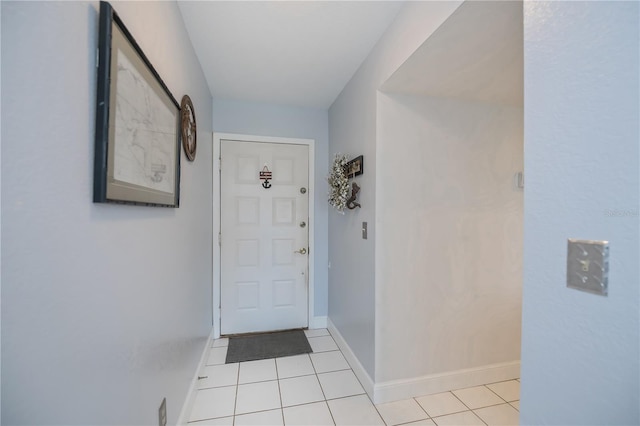 doorway to outside with light tile patterned flooring and baseboards