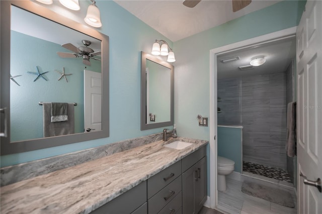 full bathroom with a ceiling fan, a stall shower, vanity, and toilet