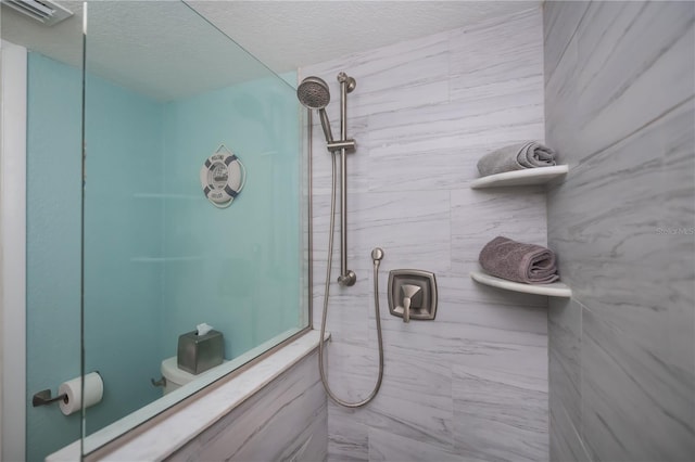 bathroom featuring visible vents, a tile shower, a textured ceiling, and toilet