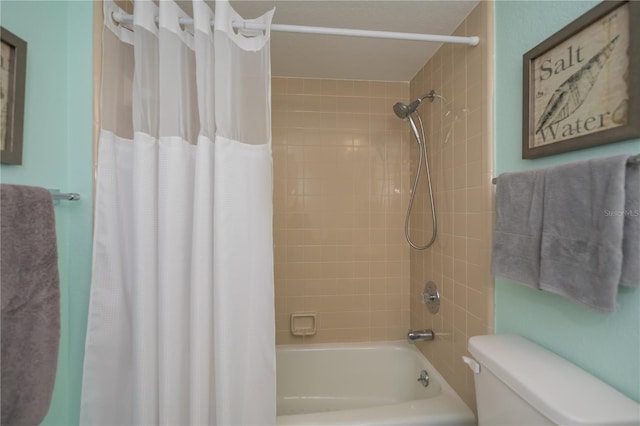 bathroom featuring shower / bath combination with curtain and toilet