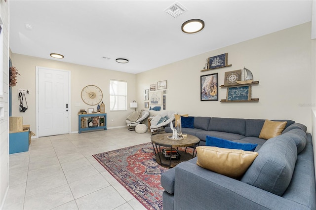 living area featuring light tile patterned floors, visible vents, and baseboards