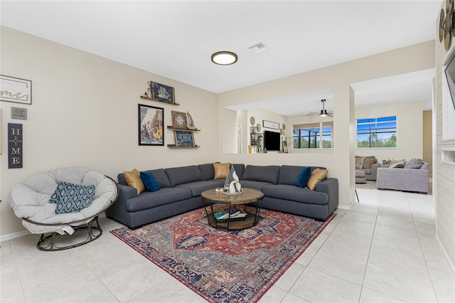 living room featuring light tile patterned floors, visible vents, and baseboards