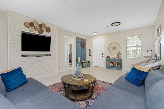 living room featuring light tile patterned floors, visible vents, and baseboards