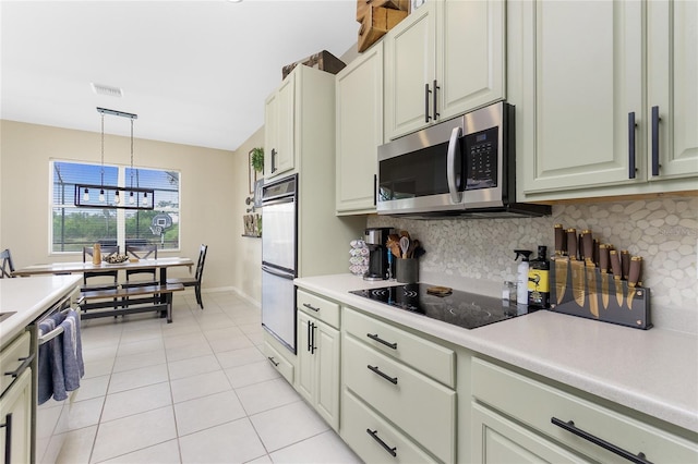 kitchen with stainless steel appliances, light countertops, visible vents, and tasteful backsplash