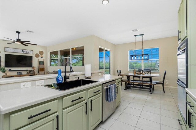 kitchen with visible vents, light countertops, stainless steel dishwasher, green cabinets, and a sink