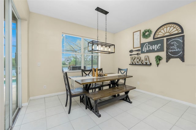 dining room featuring an inviting chandelier, baseboards, and light tile patterned floors