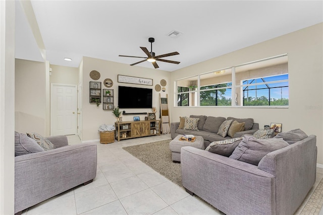 living area featuring light tile patterned floors, ceiling fan, visible vents, and baseboards