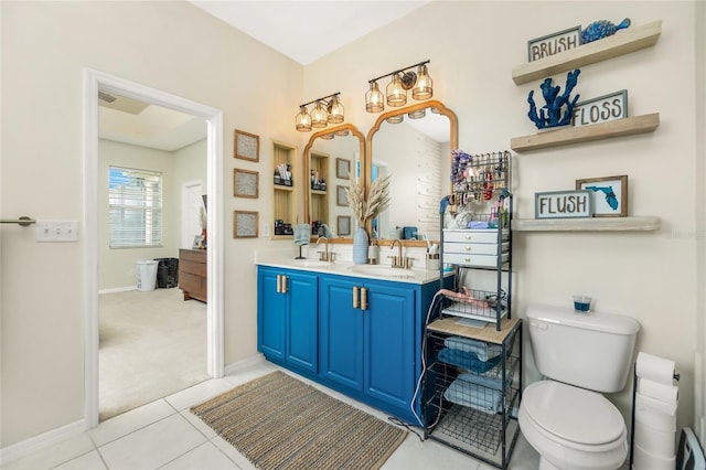 bathroom featuring toilet, double vanity, baseboards, and a sink