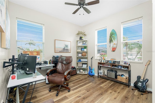 office featuring ceiling fan, plenty of natural light, wood finished floors, and baseboards