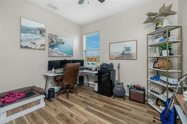 office with ceiling fan, wood finished floors, and visible vents