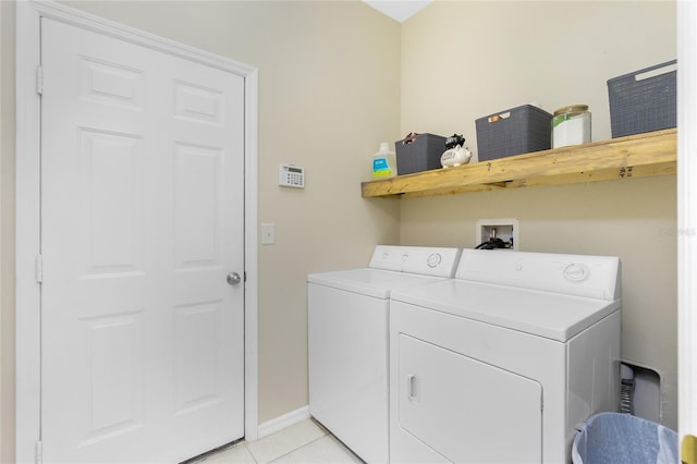 clothes washing area featuring laundry area, baseboards, light tile patterned flooring, and independent washer and dryer