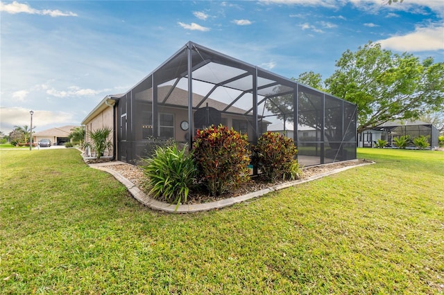 rear view of house with a yard and glass enclosure