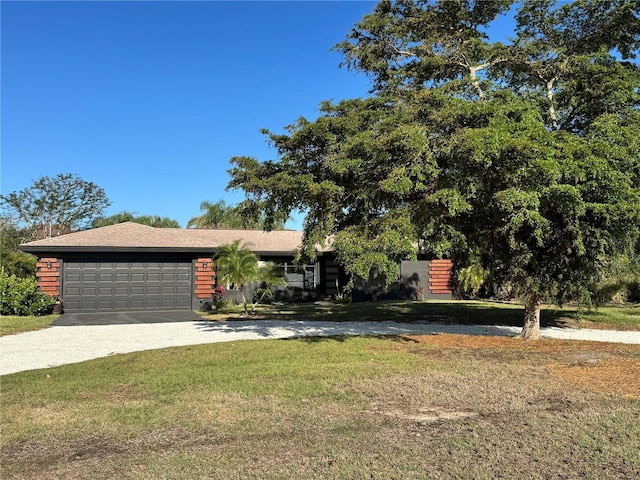 view of front of home featuring driveway, a garage, and a front lawn