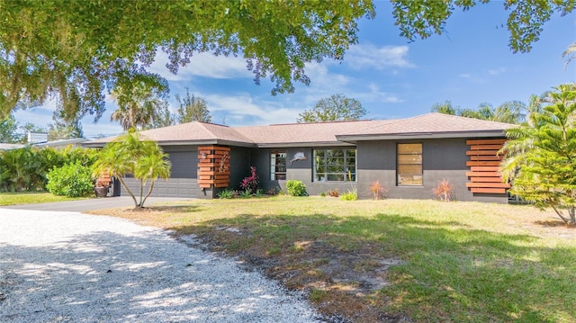 view of front of home with driveway, stucco siding, an attached garage, and a front yard