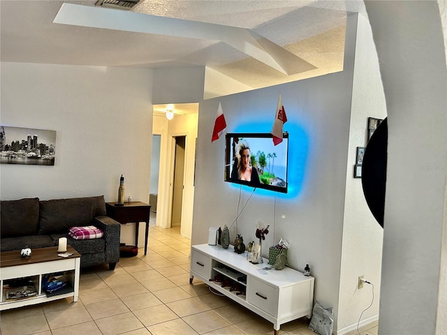 living room featuring lofted ceiling and light tile patterned floors