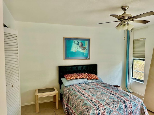 bedroom with ceiling fan, tile patterned flooring, and baseboards