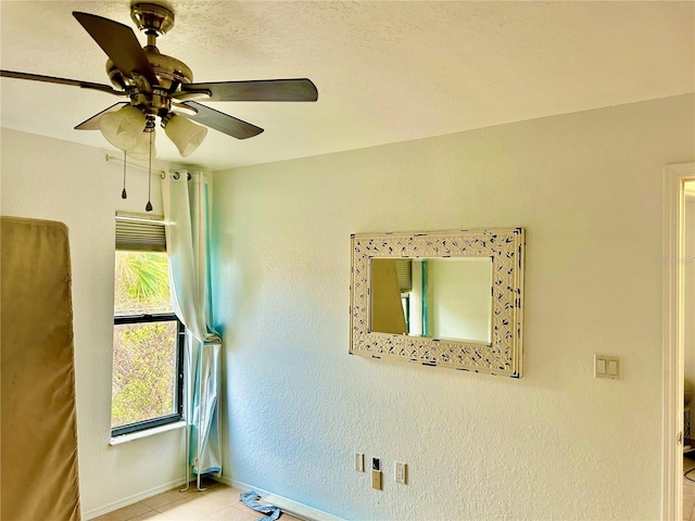 empty room with a ceiling fan and baseboards