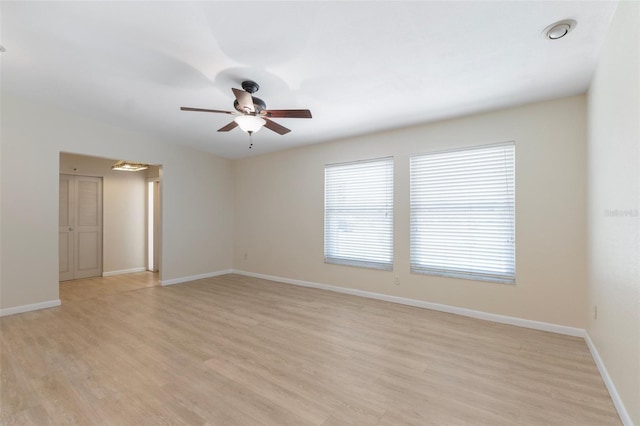 spare room with light wood-style flooring, baseboards, and a ceiling fan