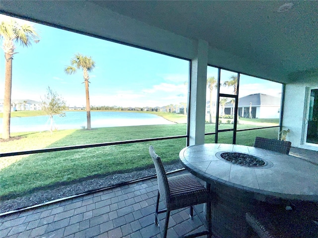 sunroom featuring a water view