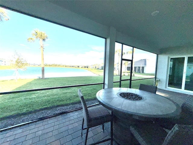 sunroom / solarium featuring a water view